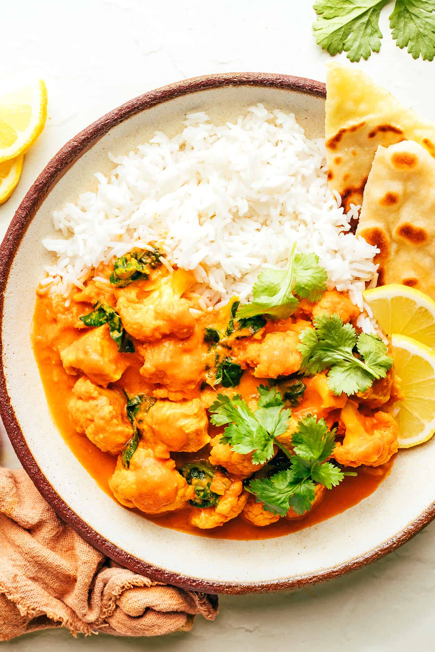 Frango com manteiga e couve-flor com arroz e naan em uma tigela