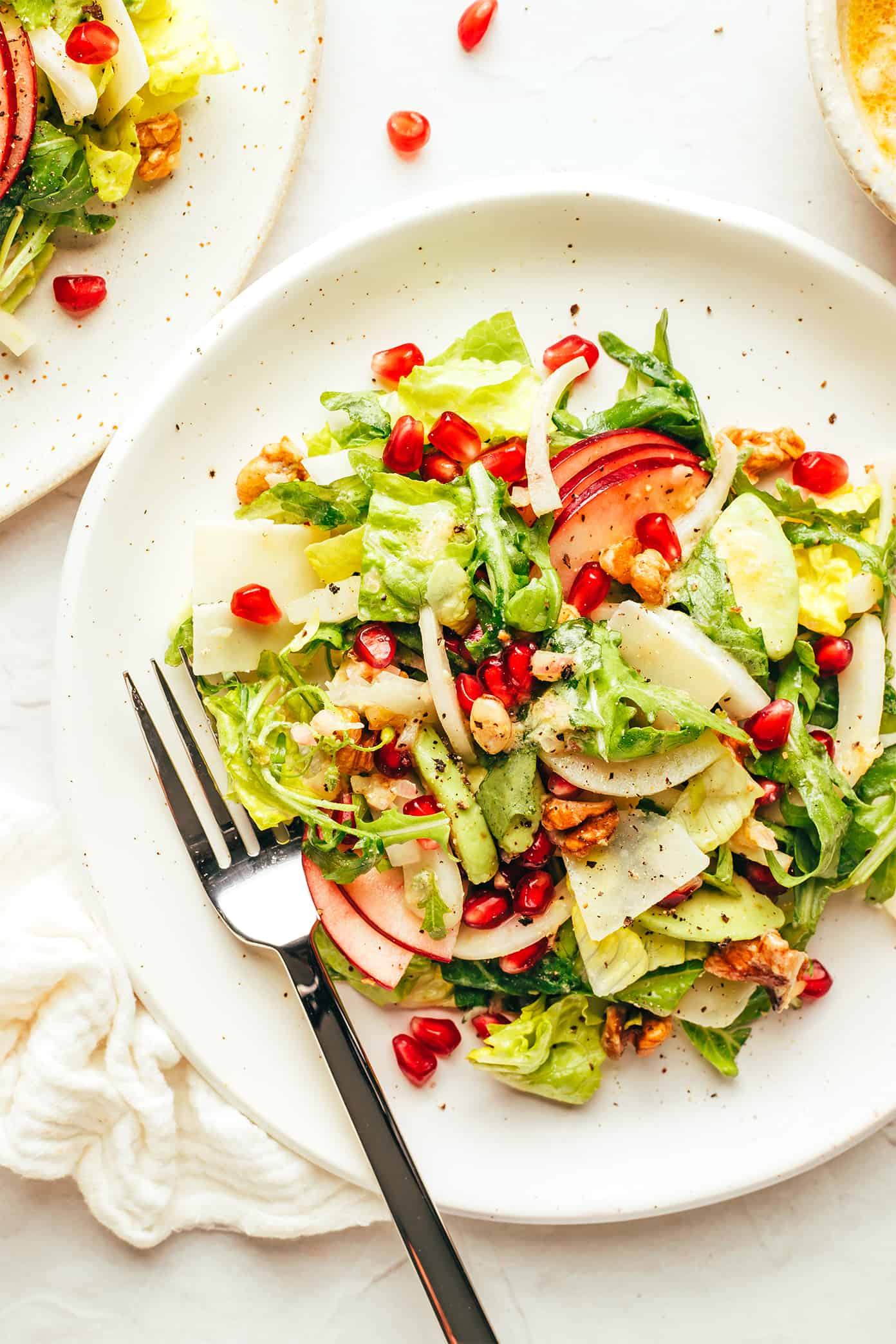 Christmas salad on a plate (with apple, pomegranate, parmesan and walnuts)