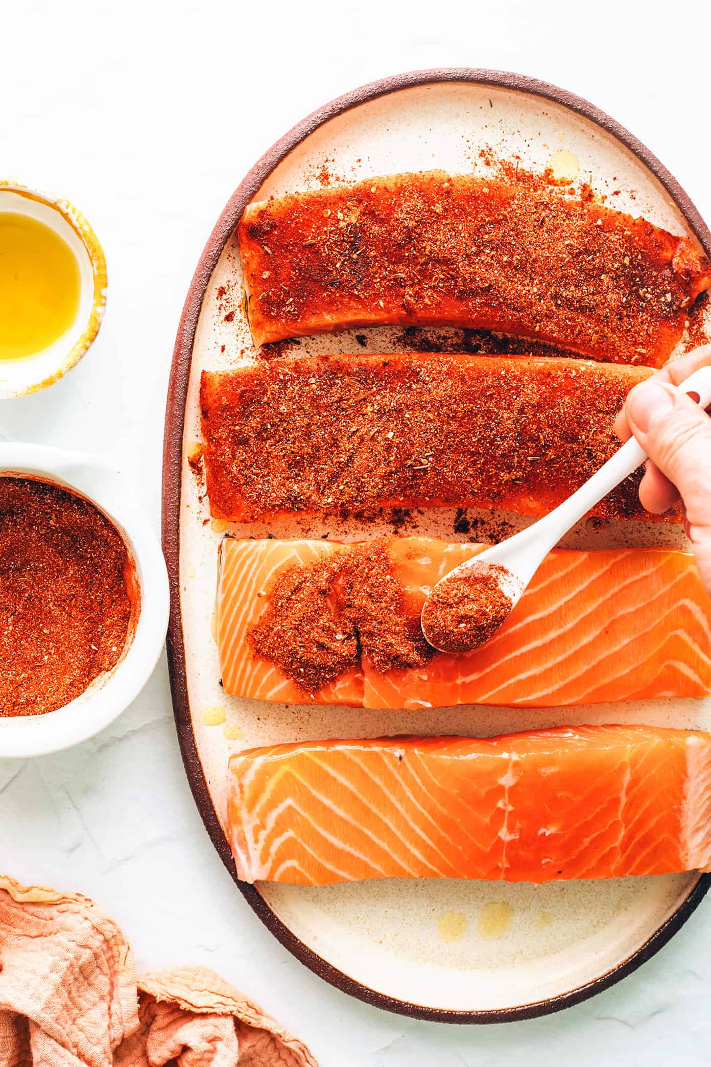 Adding blackened seasoning to salmon filets