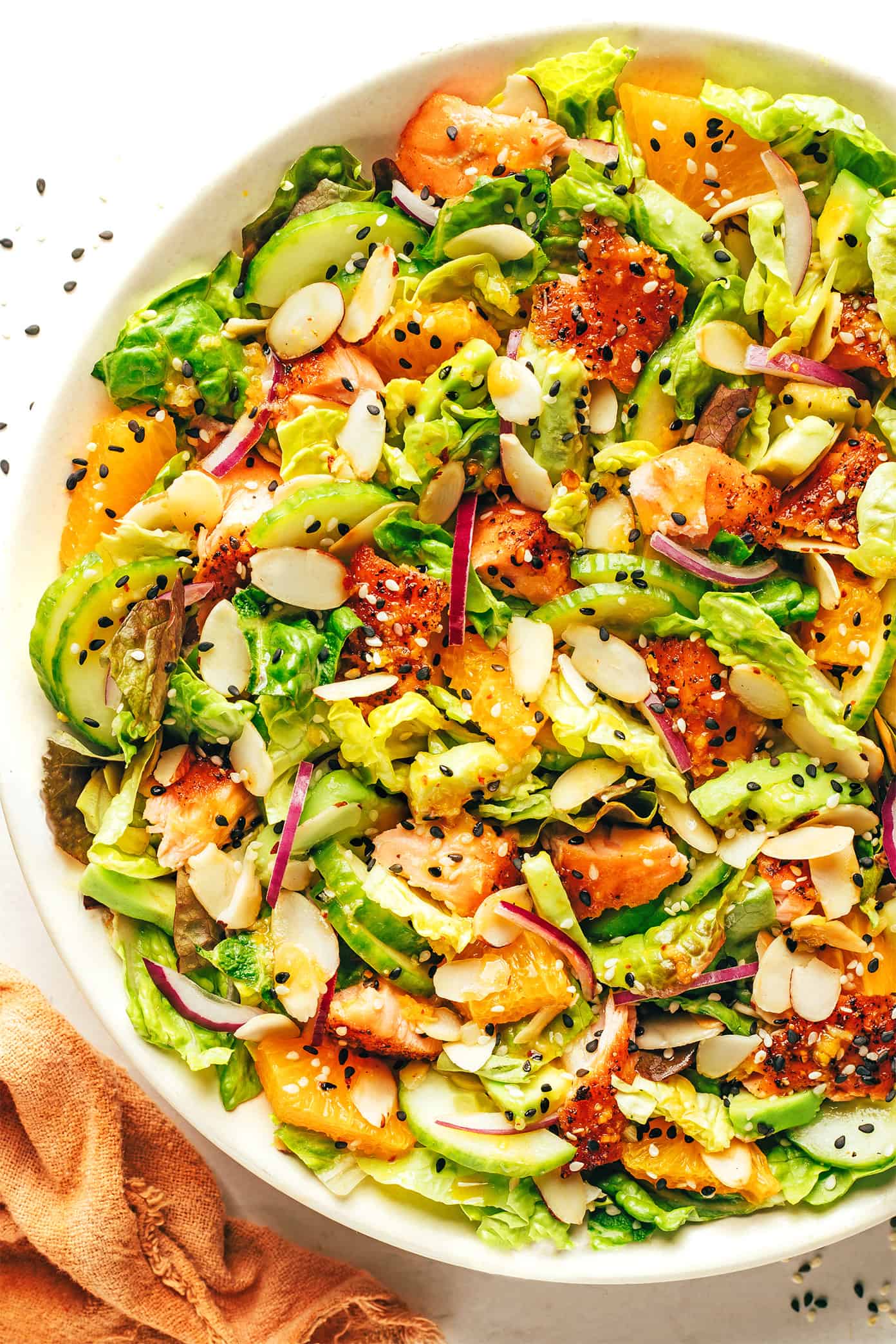 Orange salmon salad with avocado and toasted almonds in serving bowl