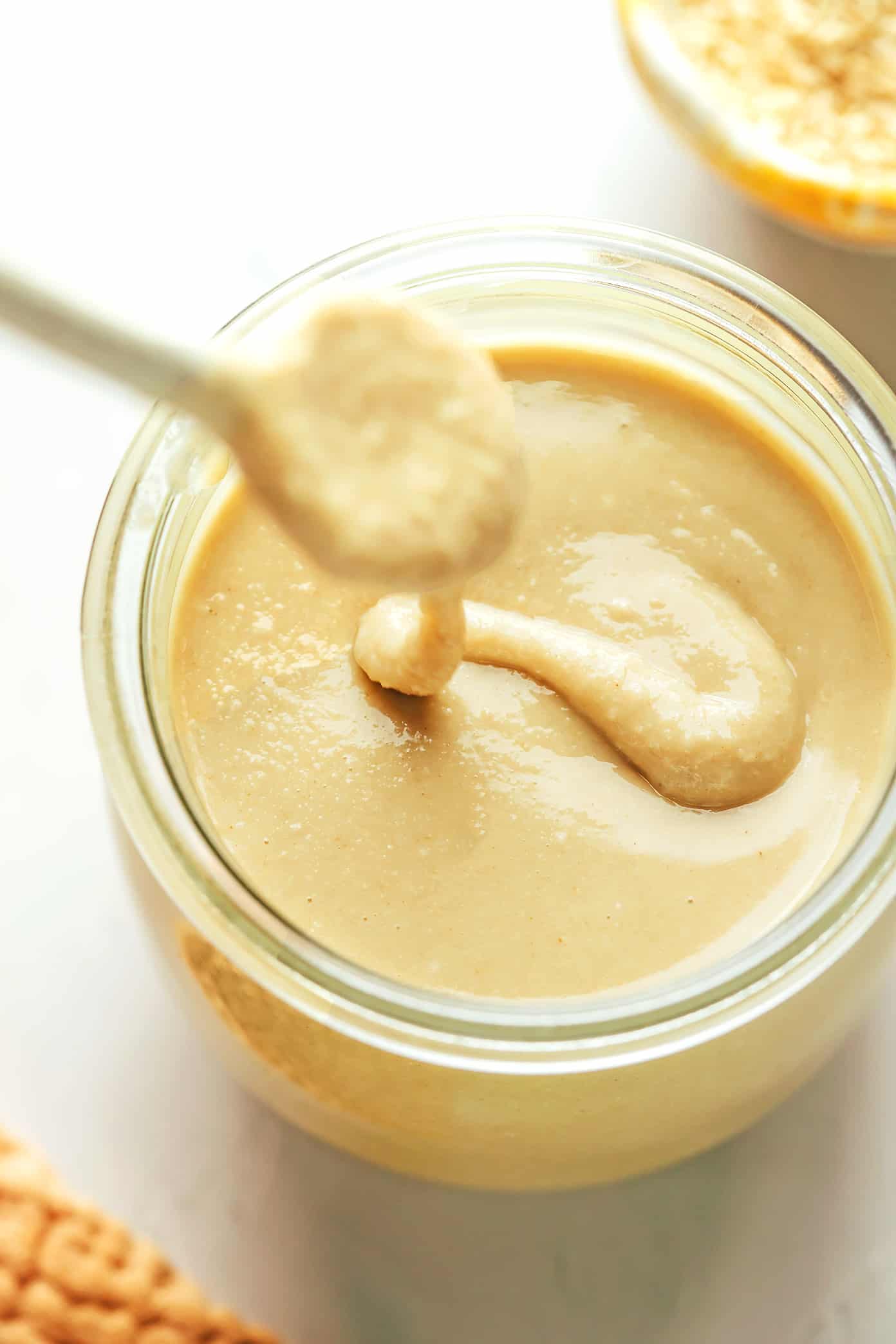 Homemade tahini drizzled into a jar