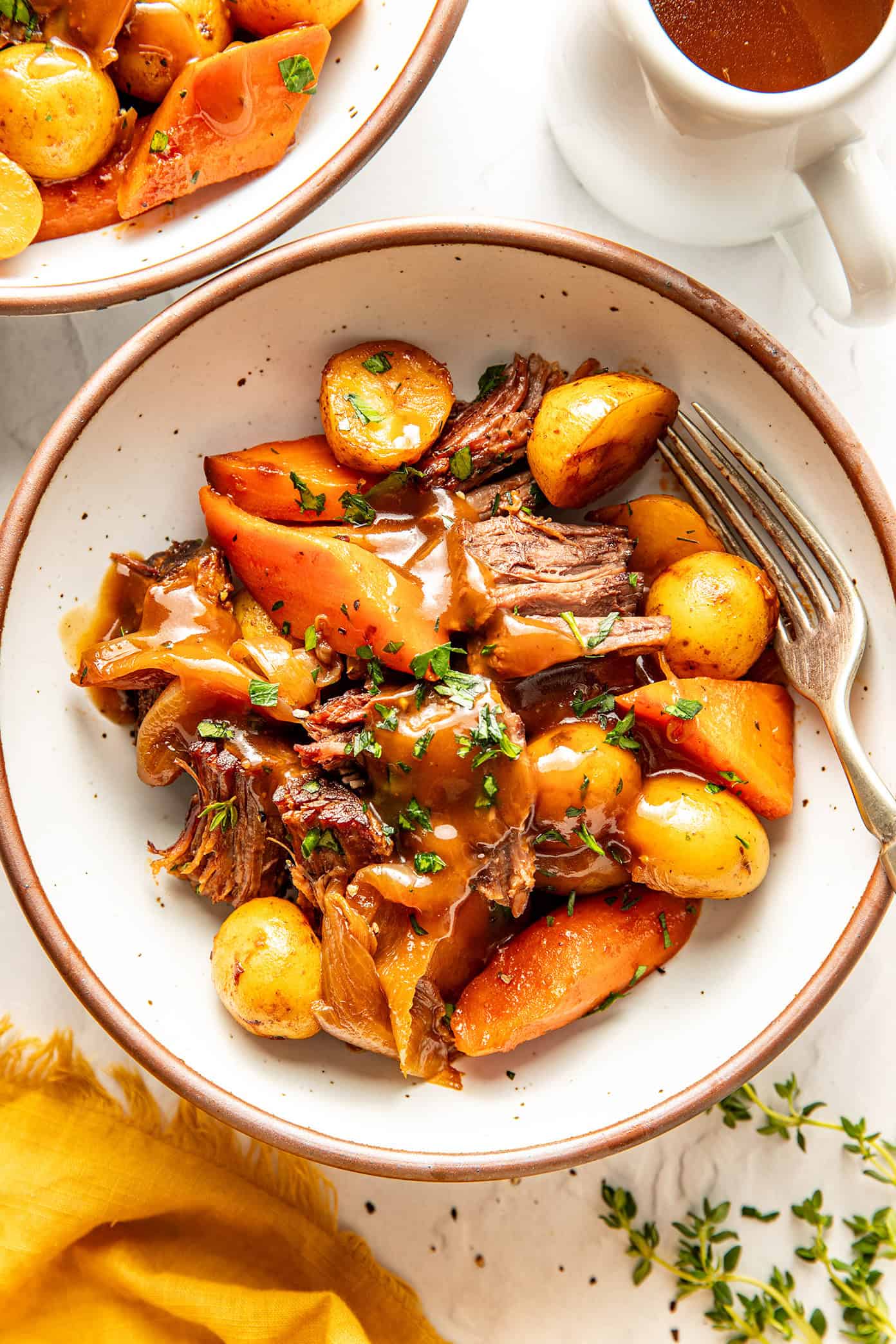 pot roast in a bowl with gravy and parsley