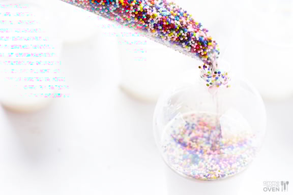 These DIY Sprinkles Ornaments are easy to make and customize with your favorite colors of sprinkles. The perfect homemade decor for your Christmas tree this year! | Gimme Some Oven